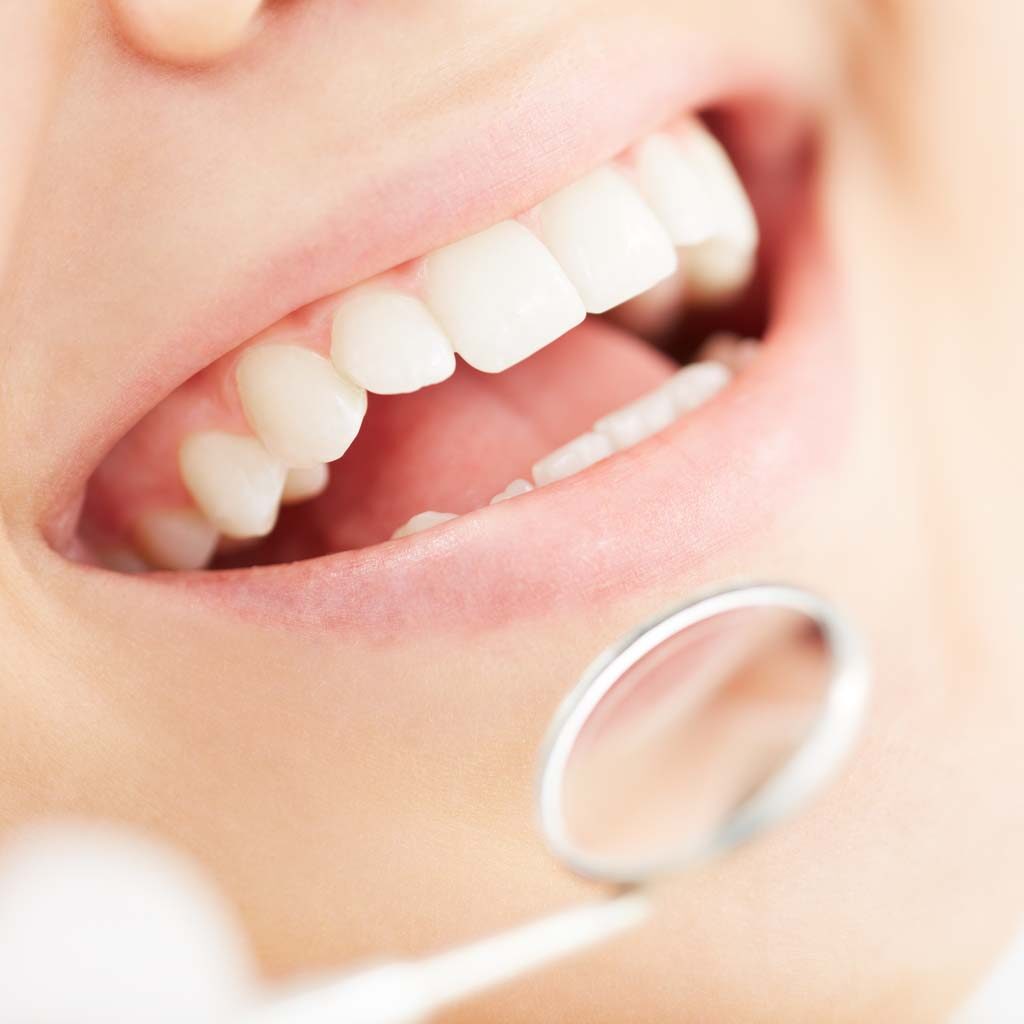 woman patient with dentist magnifying tooth